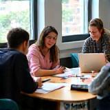 Small group English class with students collaborating at a LinguaBridge UK table