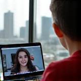 Student joining a virtual English class on laptop with London view in background